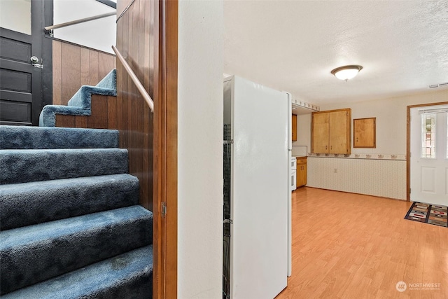 stairs featuring hardwood / wood-style floors and a textured ceiling