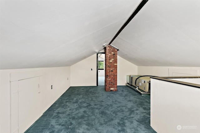 additional living space featuring dark colored carpet and lofted ceiling