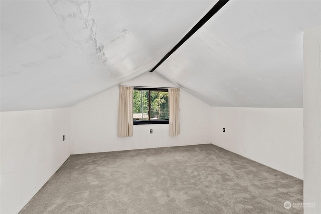 bonus room with light colored carpet and lofted ceiling