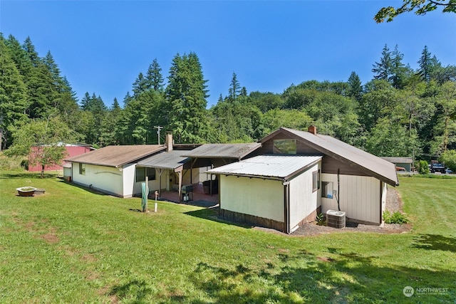 rear view of property with a yard and central AC