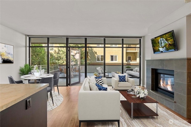 living room featuring hardwood / wood-style floors, a fireplace, and floor to ceiling windows