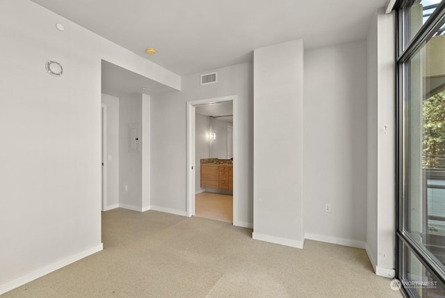 unfurnished room featuring light colored carpet, plenty of natural light, and electric panel