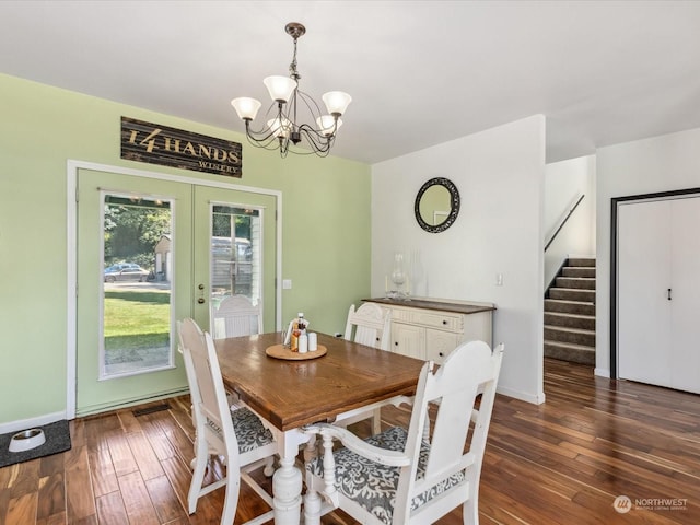 dining area with french doors, dark hardwood / wood-style flooring, and an inviting chandelier