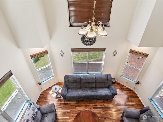 living room with dark hardwood / wood-style flooring, a chandelier, and a high ceiling