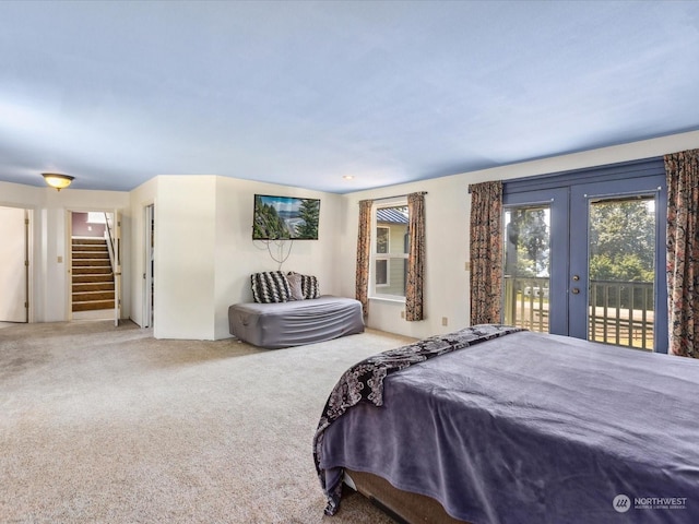 carpeted bedroom with access to exterior, a spacious closet, and french doors