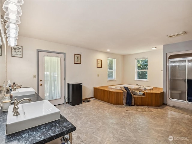 bathroom featuring vanity and independent shower and bath