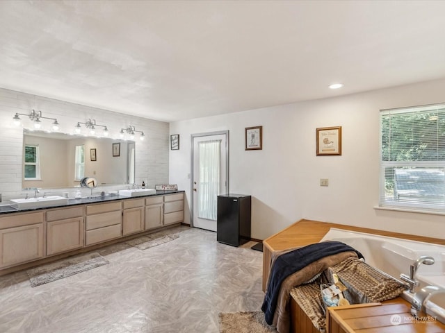 bathroom featuring a tub to relax in and vanity