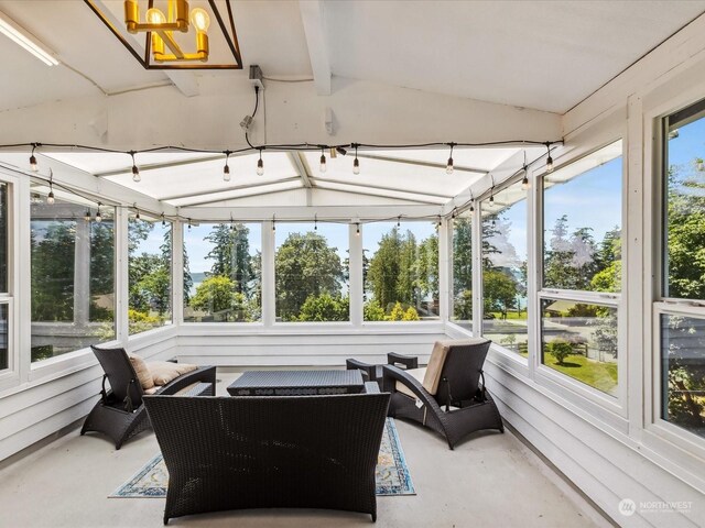 sunroom with vaulted ceiling with beams and a healthy amount of sunlight