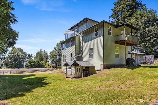 view of side of property featuring a lawn and a balcony