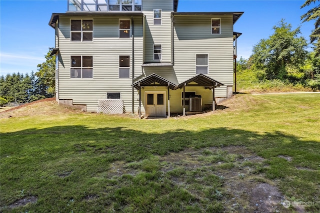 rear view of house with a lawn and central air condition unit