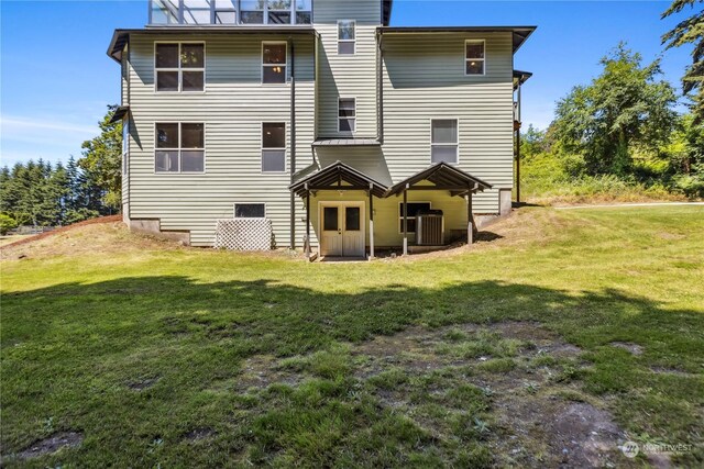 back of house with a lawn and central AC unit