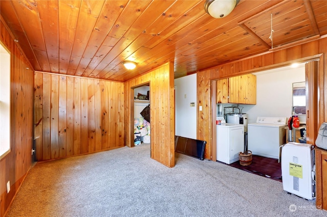 laundry room with wooden walls, independent washer and dryer, electric water heater, light carpet, and wooden ceiling