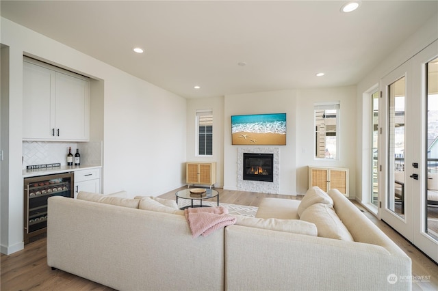 living room with wine cooler, bar area, and light hardwood / wood-style floors