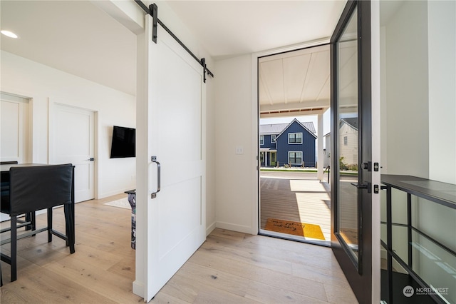 interior space with a barn door and light wood-type flooring