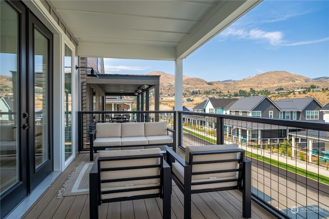 wooden deck featuring a mountain view and an outdoor hangout area