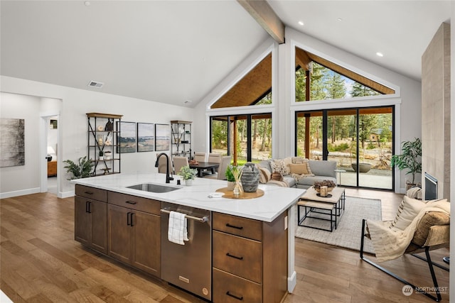 kitchen featuring a sink, a wealth of natural light, open floor plan, and beam ceiling