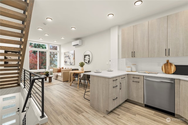 kitchen featuring stainless steel dishwasher, light hardwood / wood-style flooring, kitchen peninsula, a wall unit AC, and light brown cabinets