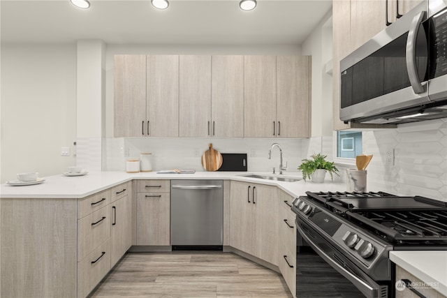 kitchen featuring sink, light brown cabinetry, appliances with stainless steel finishes, and tasteful backsplash