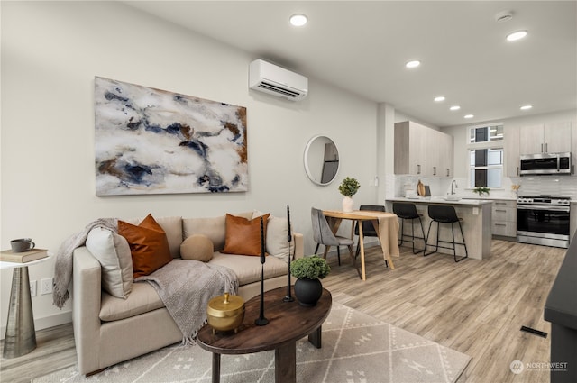 living room with light hardwood / wood-style floors and a wall mounted AC