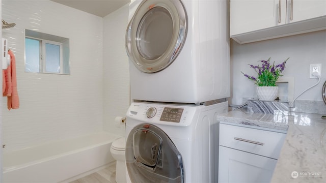 laundry room with stacked washing maching and dryer