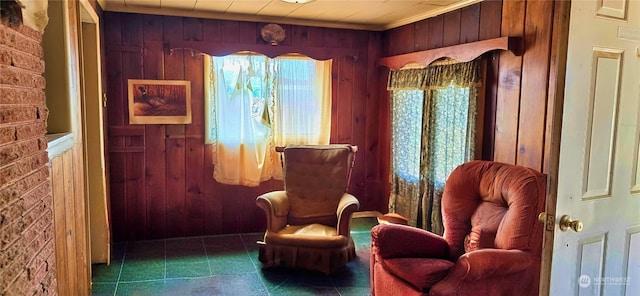 living area with tile patterned flooring and wooden walls