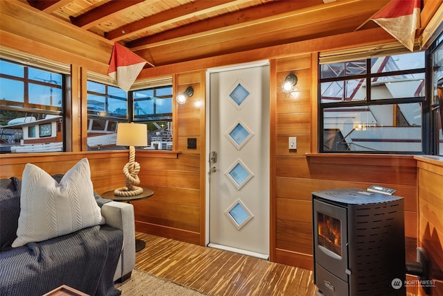 living room with beamed ceiling, wooden walls, and wood ceiling