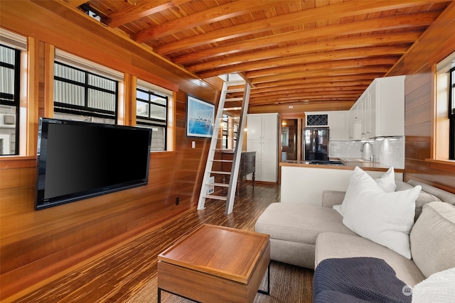 unfurnished living room featuring dark wood-type flooring, wood walls, wood ceiling, and sink