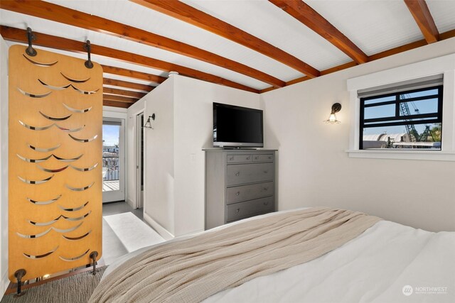 bedroom with beamed ceiling, multiple windows, and carpet floors