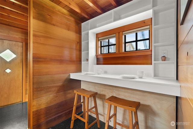 interior space with wood walls, beam ceiling, and wooden ceiling