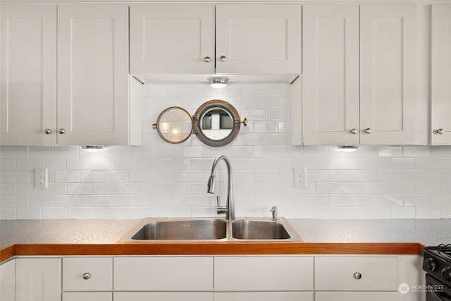 kitchen with sink, white cabinets, and backsplash