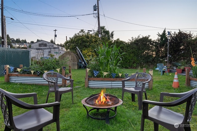 view of yard featuring a storage unit and an outdoor fire pit