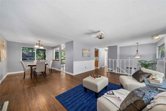 living room featuring dark hardwood / wood-style floors, a healthy amount of sunlight, and a textured ceiling