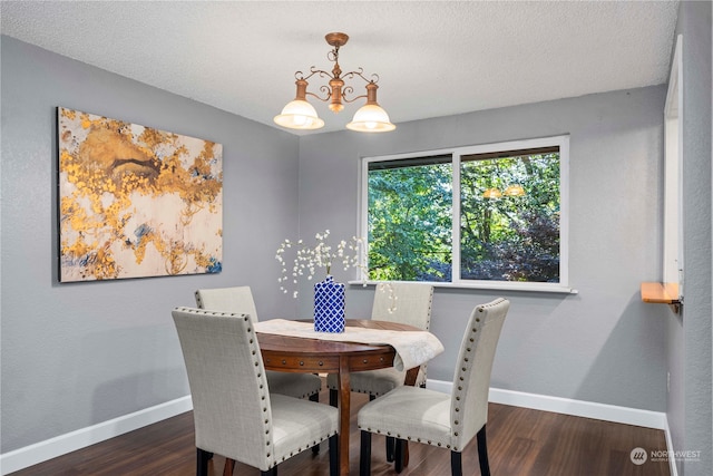 dining area featuring a textured ceiling, a chandelier, and dark wood-type flooring