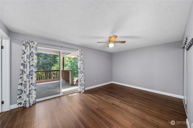 spare room featuring a textured ceiling, wood finished floors, visible vents, a ceiling fan, and baseboards