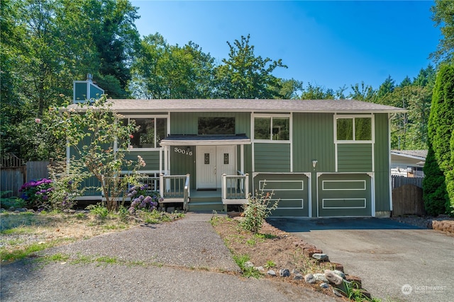 raised ranch featuring a porch and a garage