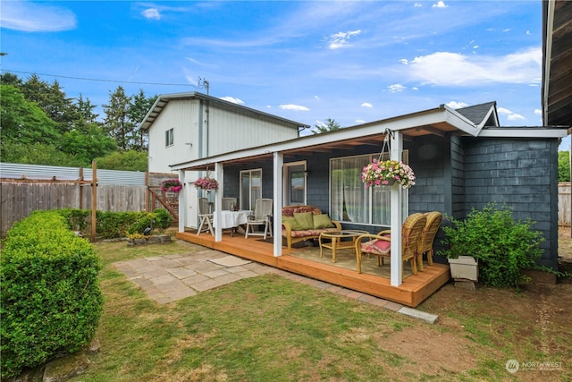 rear view of property with a yard, an outdoor hangout area, and a wooden deck