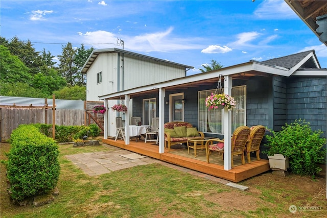 back of house with a lawn, an outdoor hangout area, and a deck