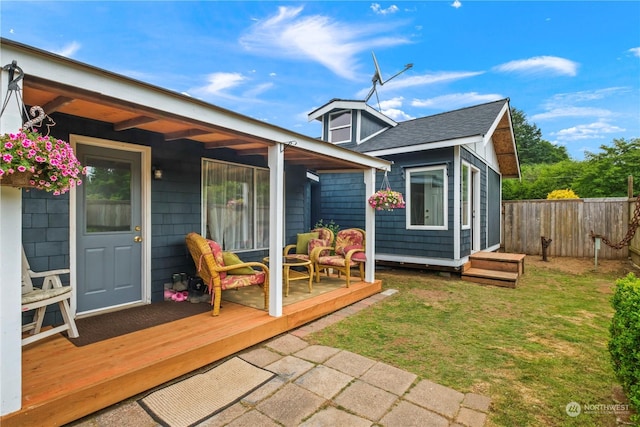 rear view of house with a lawn and a wooden deck