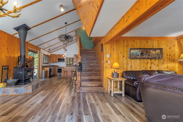 252 Snyder Rd, Packwood, WA 98361 - living room with wooden walls, a wood stove, wood-type flooring, and vaulted ceiling with beams