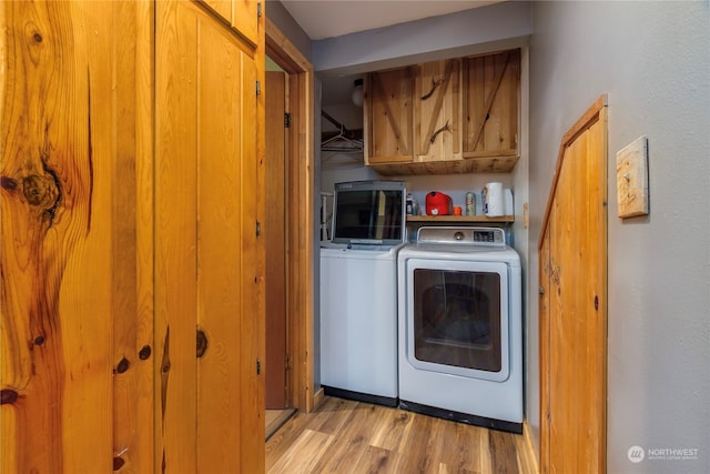 252 Snyder Rd, Packwood, WA 98361 - washroom with washing machine and clothes dryer, light hardwood / wood-style flooring, and cabinets