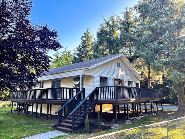 rear view of property with a yard and a wooden deck