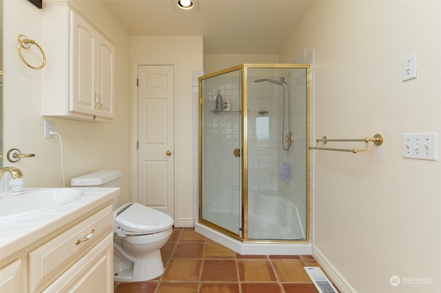 bathroom featuring a shower with shower door, vanity, tile patterned flooring, and toilet