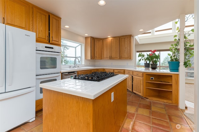 kitchen with white appliances, a wealth of natural light, tile countertops, and light tile patterned floors