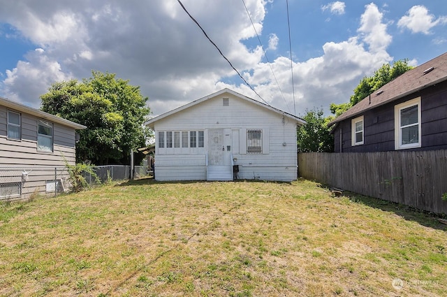 rear view of property with a lawn