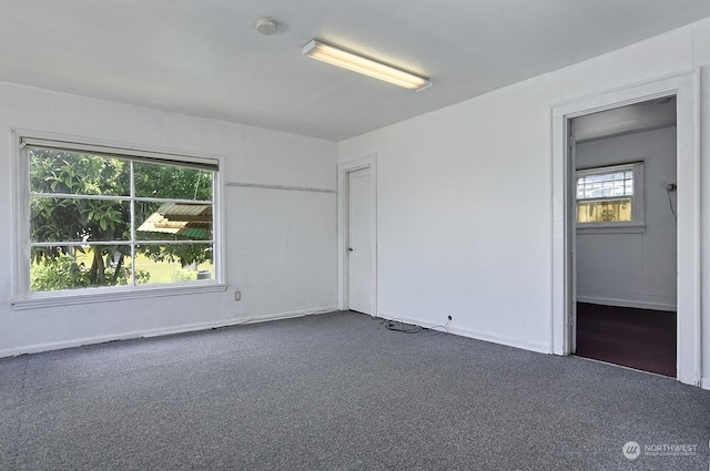 unfurnished room with dark colored carpet