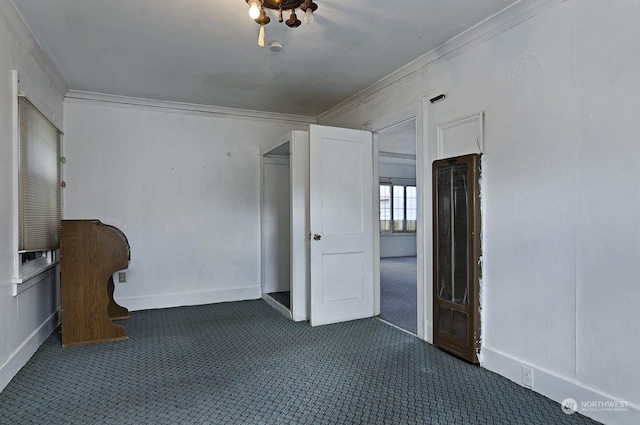 unfurnished bedroom with dark colored carpet and crown molding