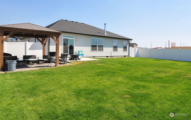 rear view of property featuring a gazebo, a yard, a patio area, and fence