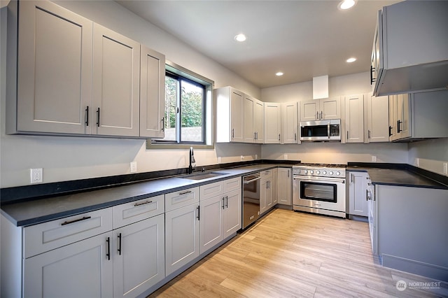 kitchen featuring stainless steel appliances, sink, gray cabinetry, and light hardwood / wood-style floors