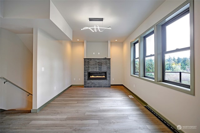 unfurnished living room featuring a fireplace and light hardwood / wood-style floors