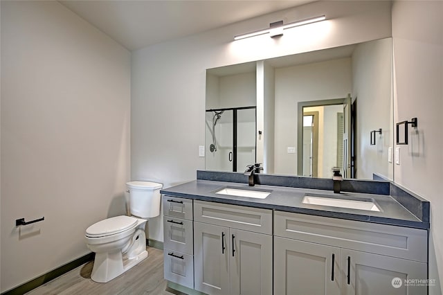 bathroom featuring vanity, wood-type flooring, toilet, and walk in shower